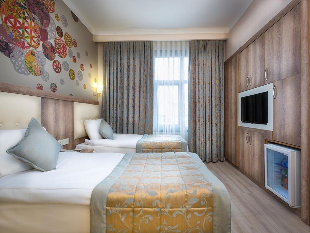 A hotel room with two beds and a television.