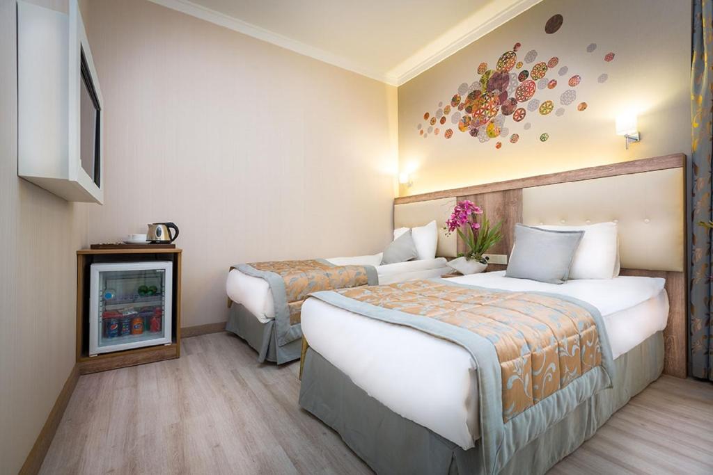 Fatih Hotel Corner, A hotel room with two beds and a refrigerator.