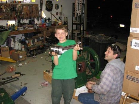 Child holding generator part with man looking at him with a smile on his face