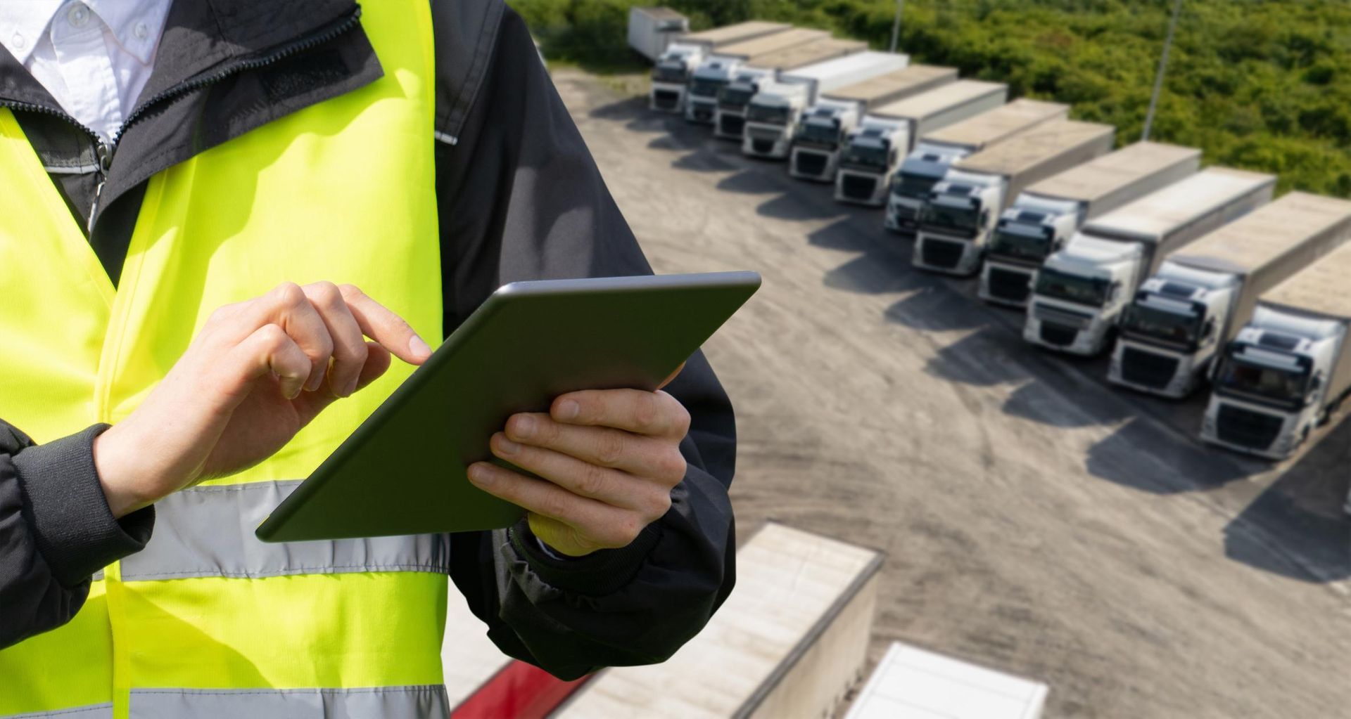 A miniature red car sitting on a pile of scattered coins, with a tall stack of coins behind it on a light surface.