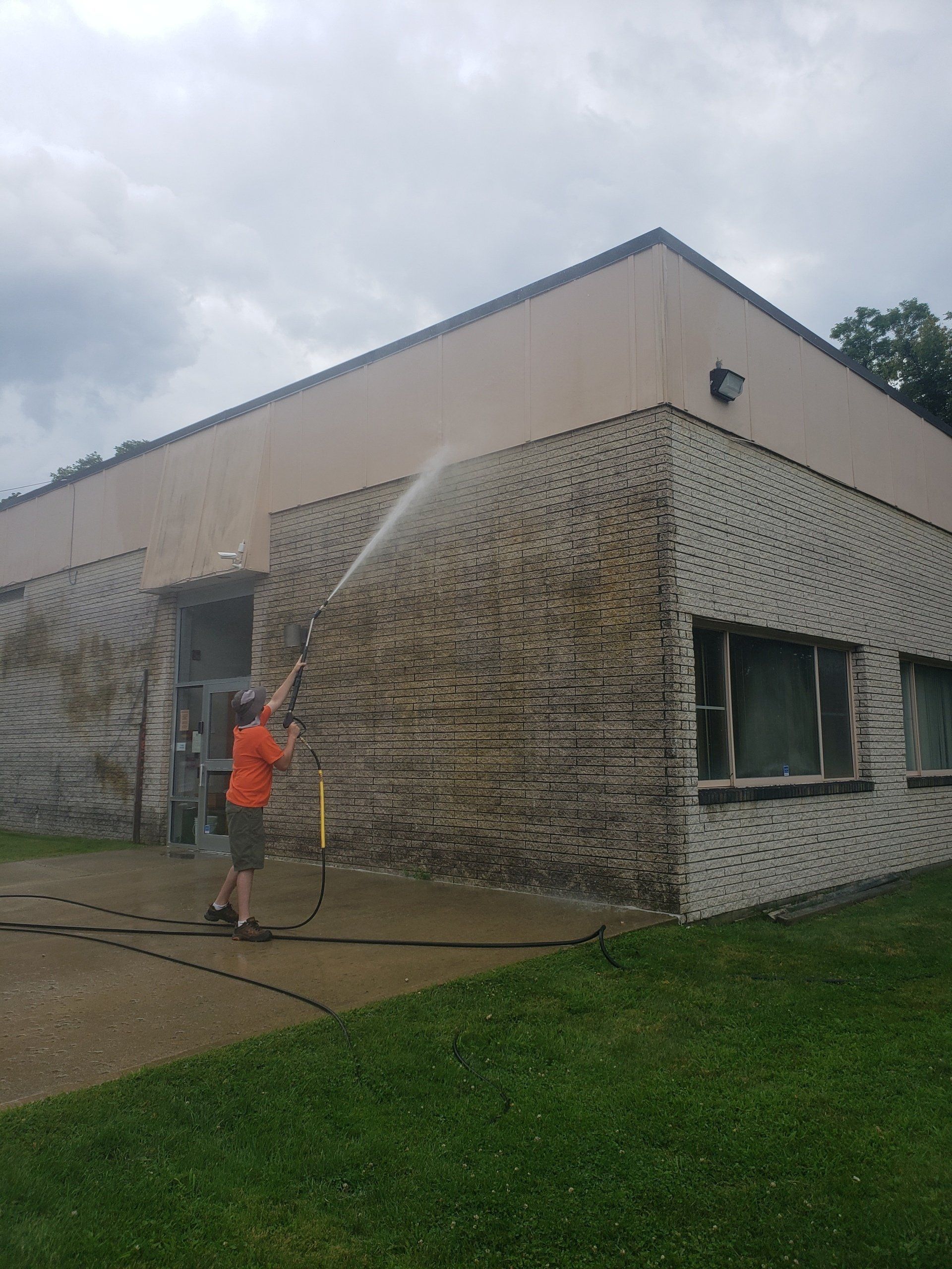 Professional Worker Cleaning a Dirty Wall — Arlington, NY — 6 Star Power Washing