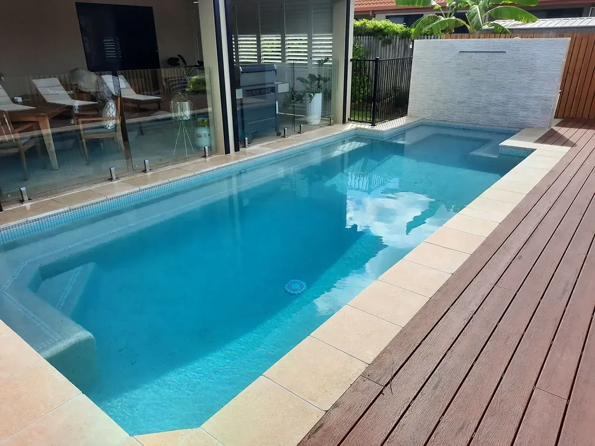 A Large Swimming Pool Is Sitting On Top Of A Wooden Deck — Tropical North Swimming Pools 'n' Spas In Currajong, QLD