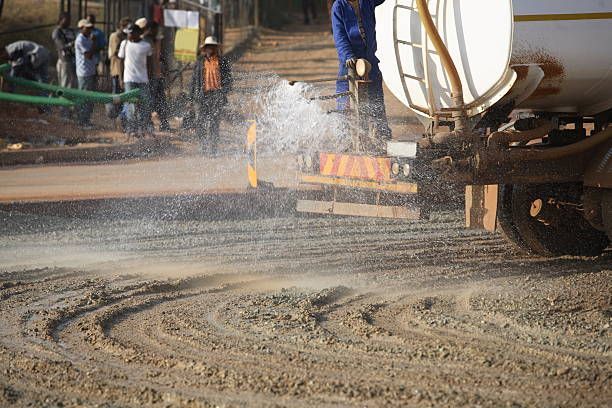 Hydroseeding truck and crew applying green mulch to an embankment.