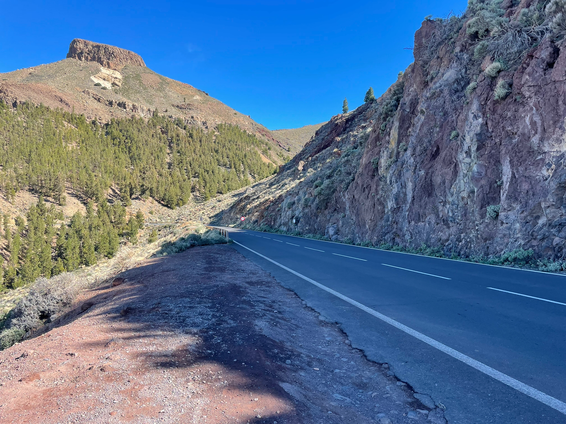A road going through a valley with mountains in the background.