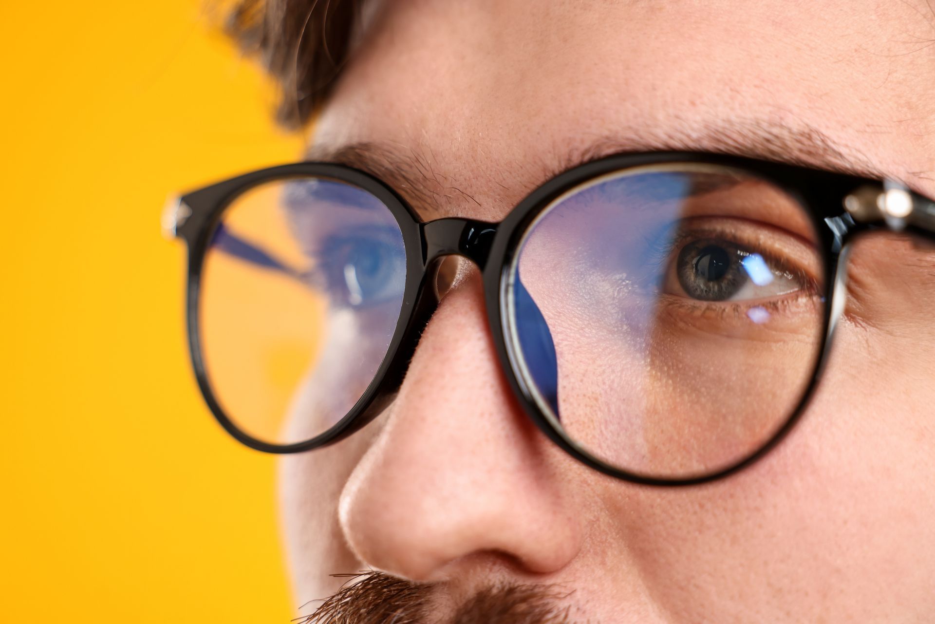 Close-up of a man wearing stylish black frames with high-quality vision shaping lenses.