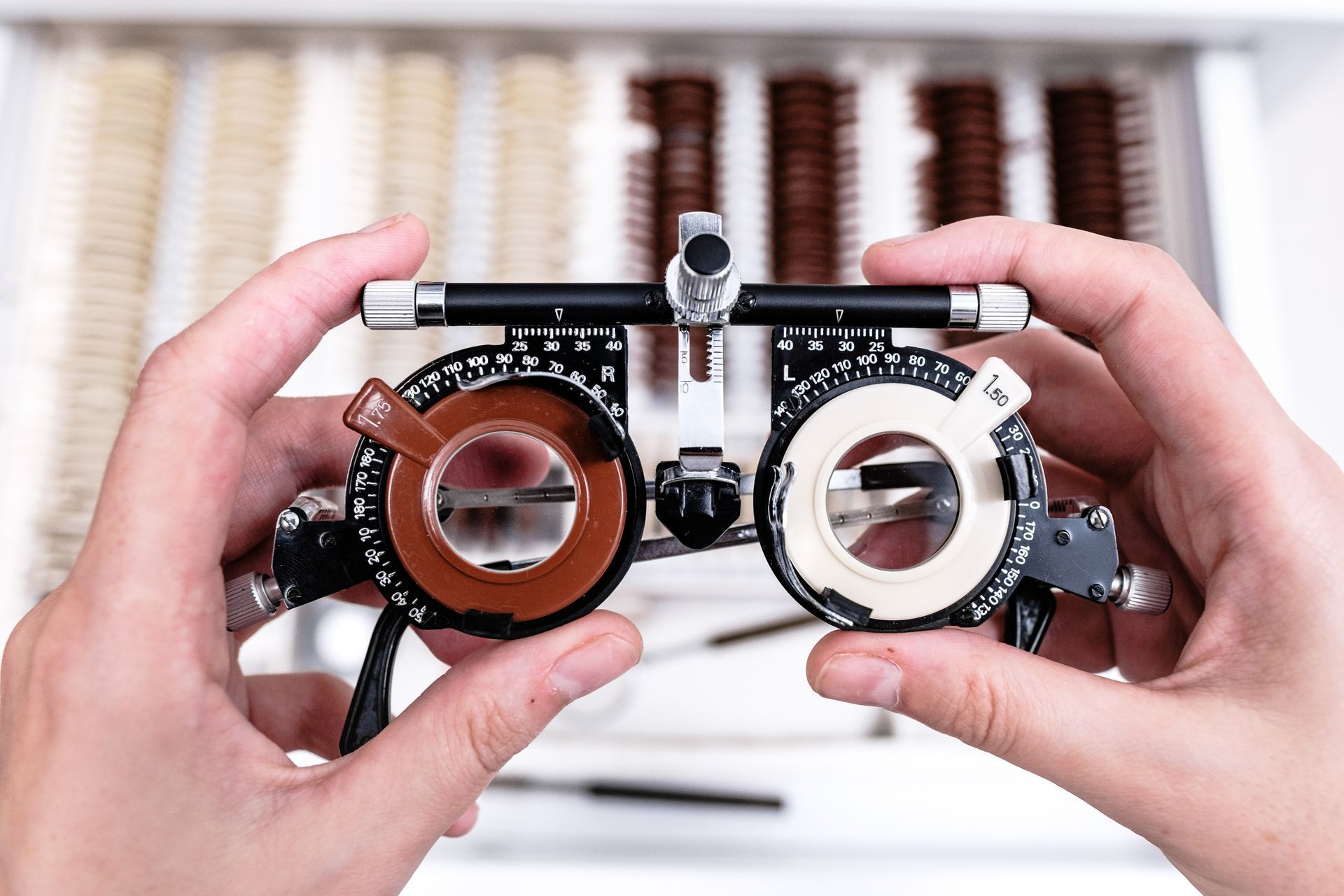 Optometrist hands adjusting trial frames for custom vision shaping lenses in a clinic.