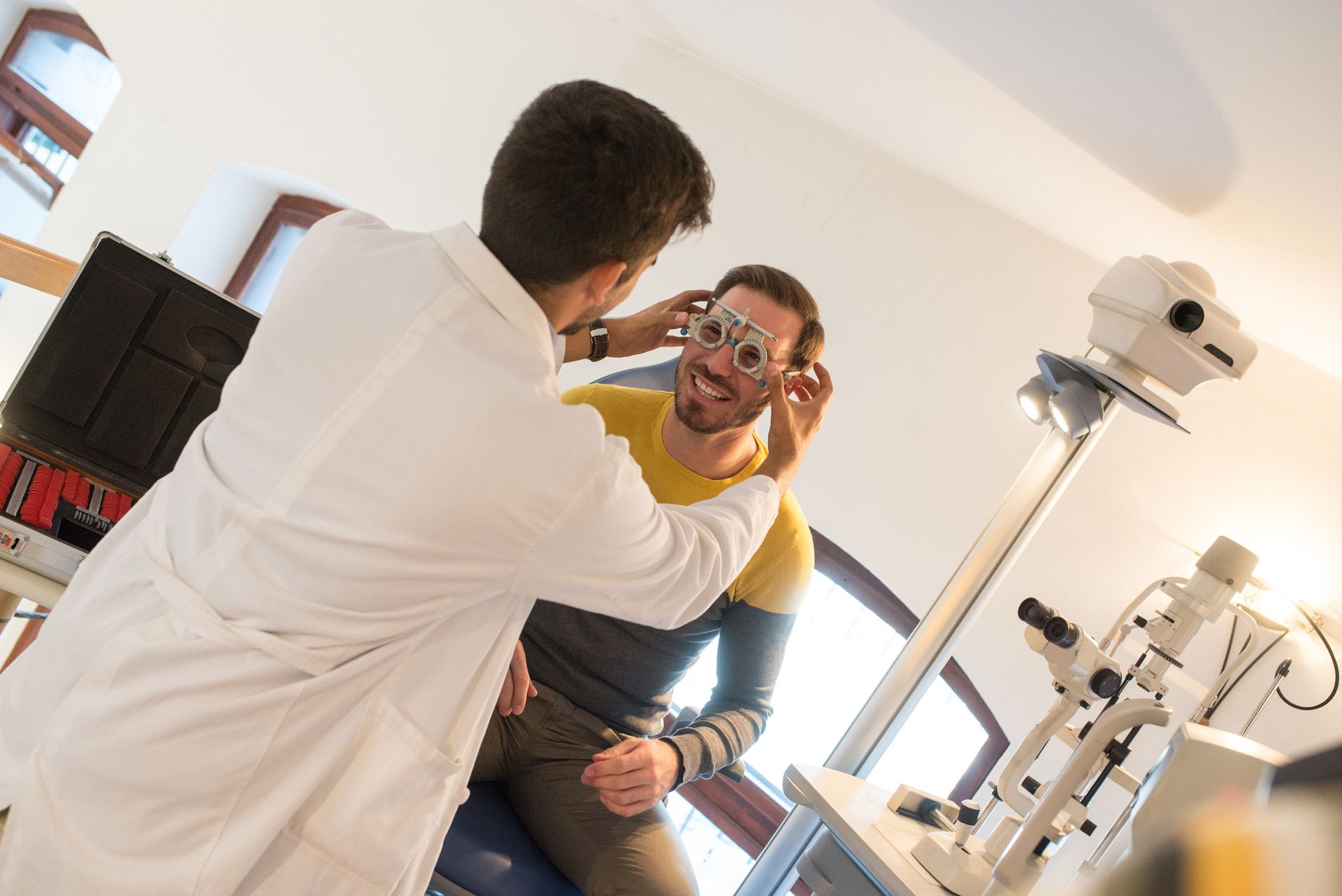 Optometrist performing eye exam with professional equipment in a modern vision care clinic.