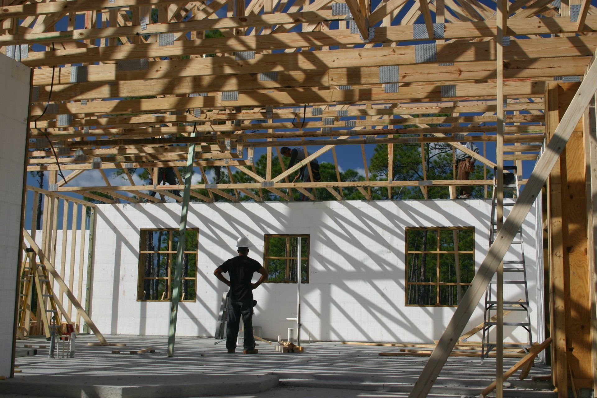 Construction site: worker in hard hat stands inside unfinished building
