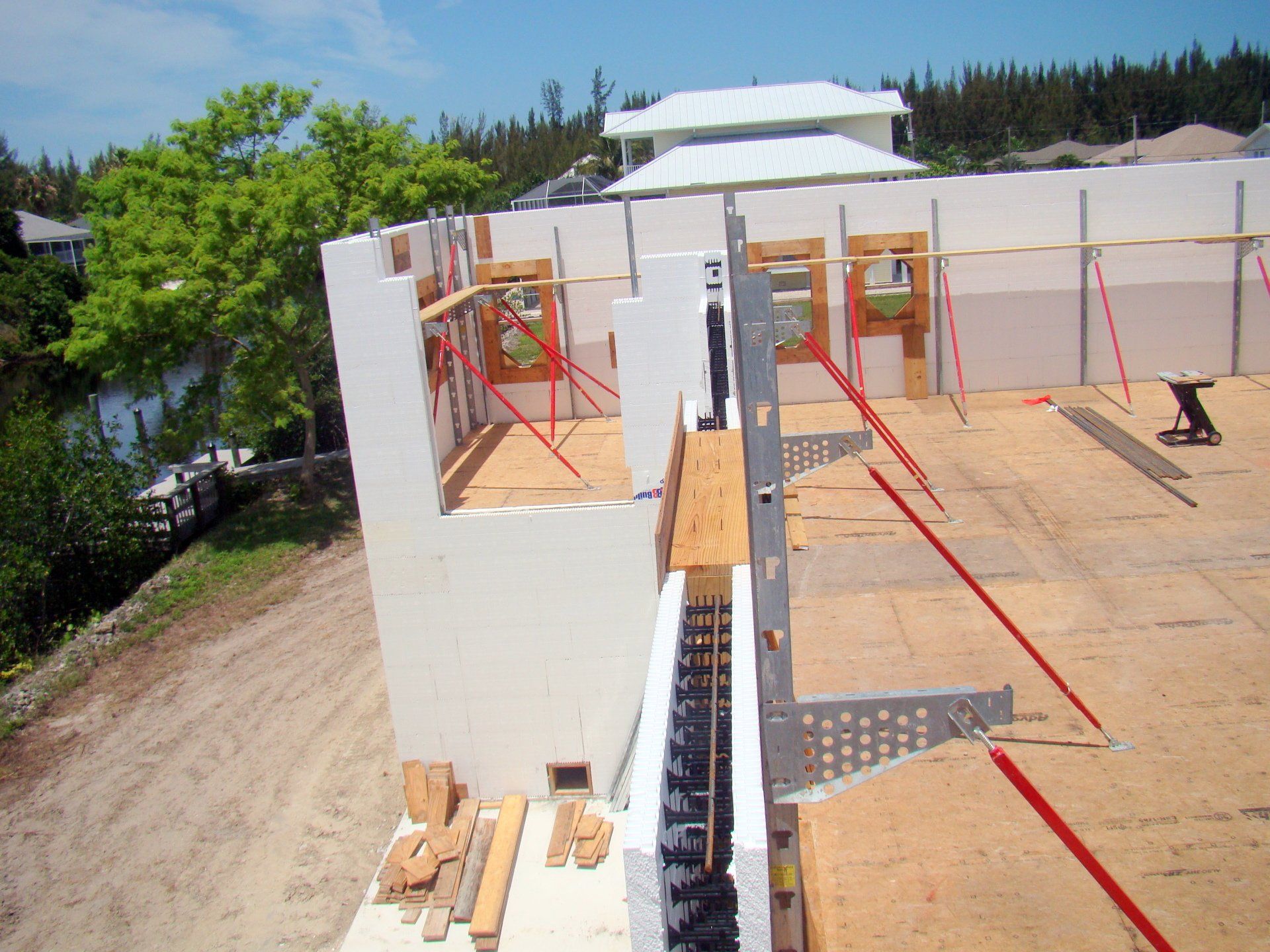 Construction site with white insulated concrete forms and wooden supports.