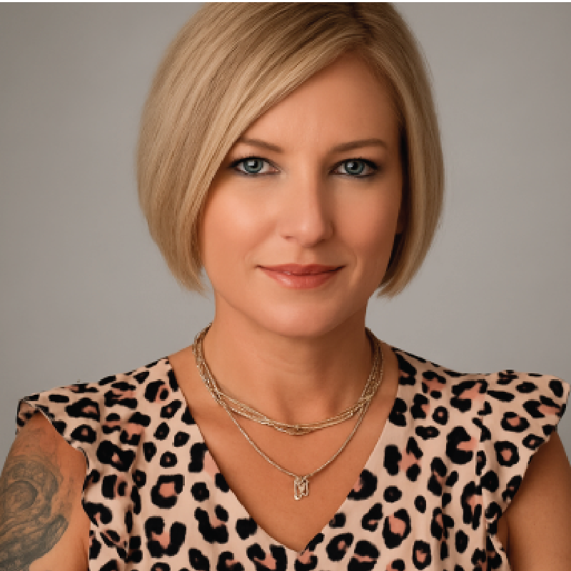Woman with blonde bob and leopard print top, wearing necklaces.