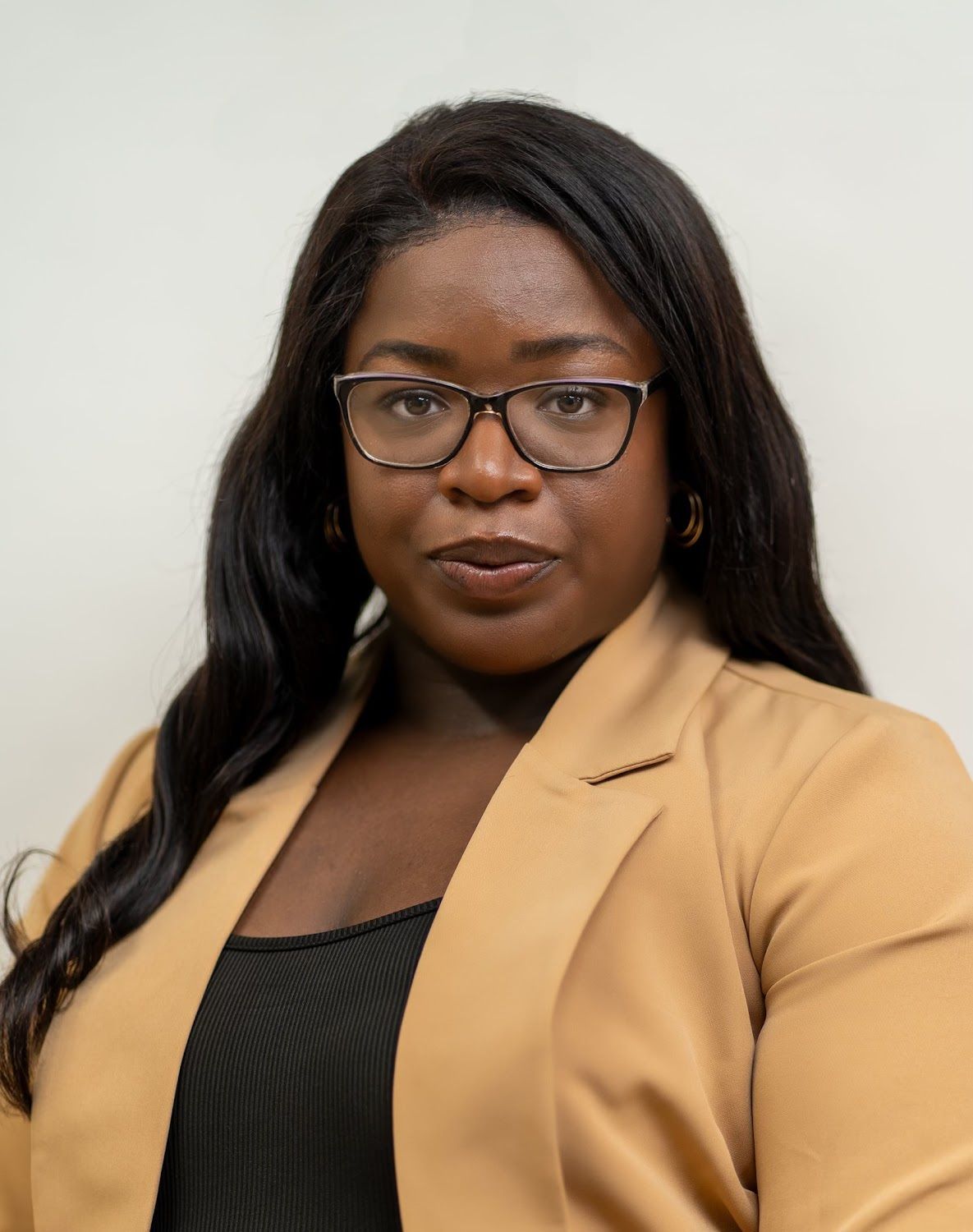 A man in a suit shakes hands with another man in a blue shirt