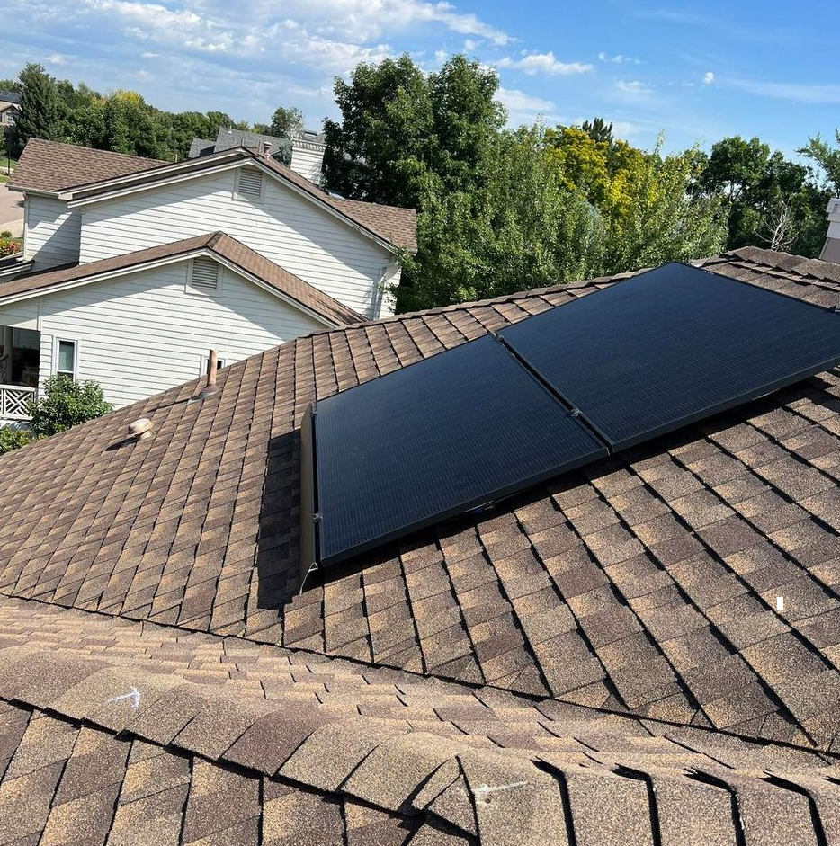 A solar panel is sitting on the roof of a house