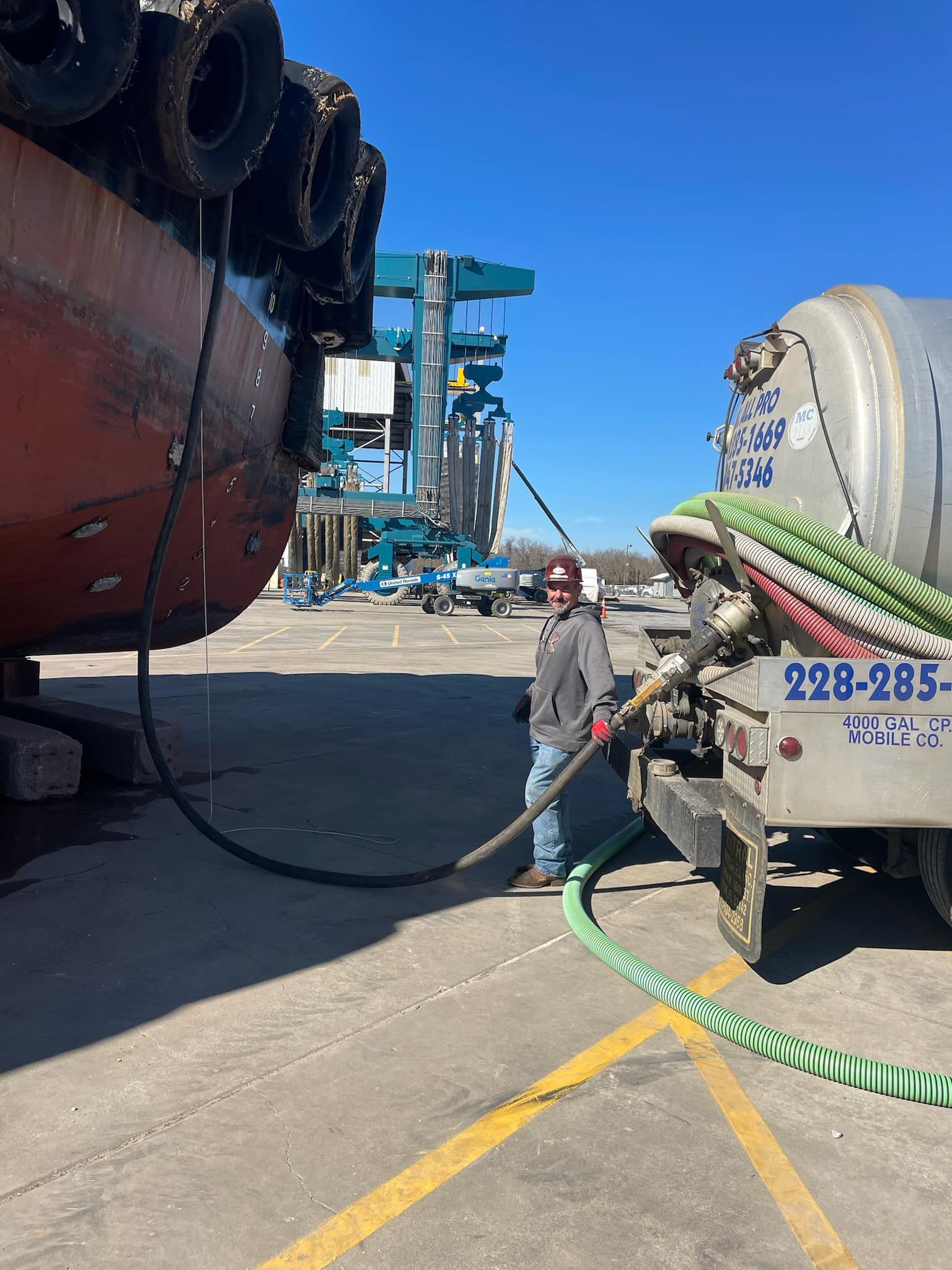 Heavy Duty Pumping | A man is standing next to a vacuum truck with the number 229-285 on the back.