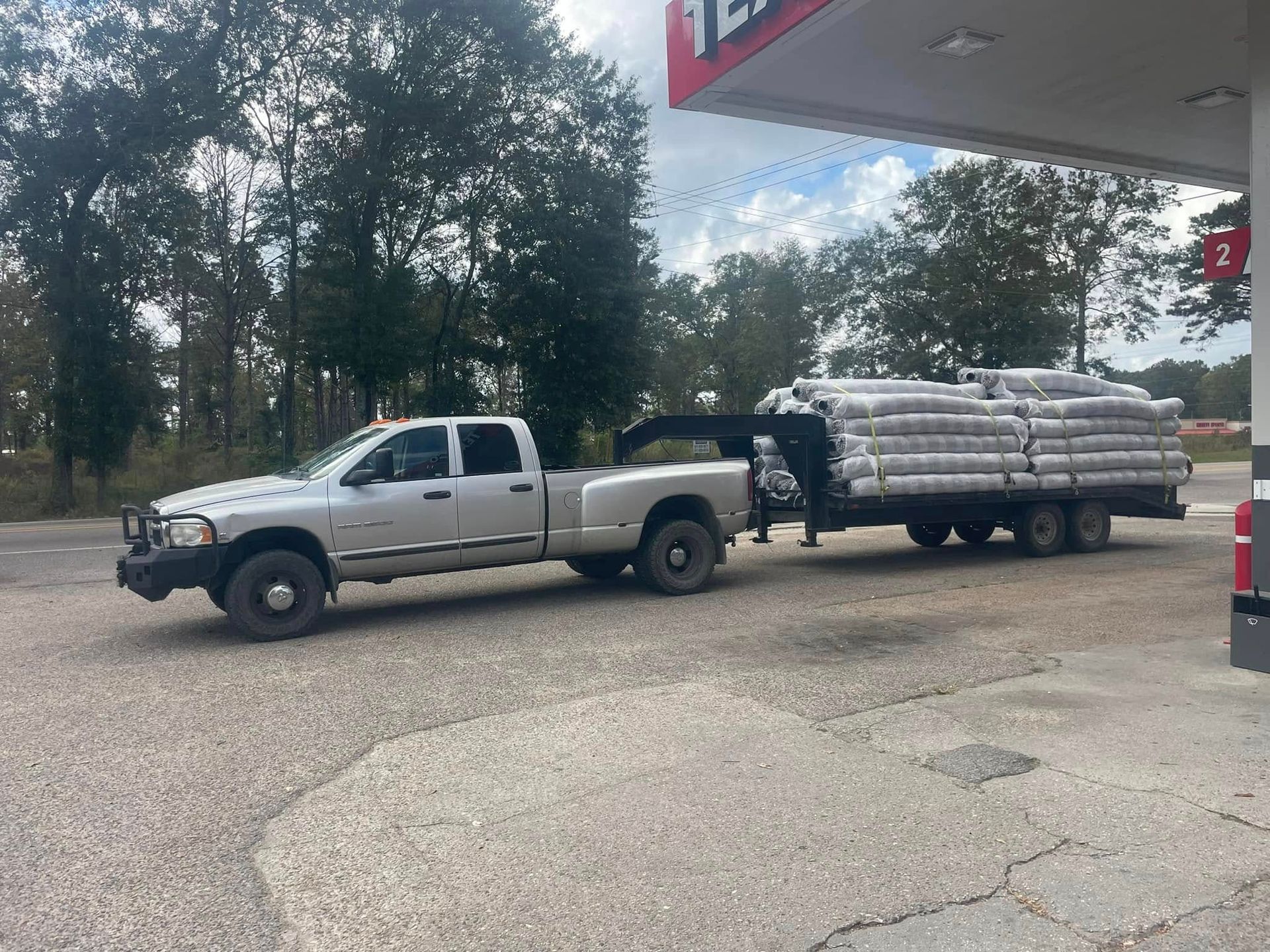 Heavy Duty Pumping | A white truck is towing a trailer with a crane attached to it.
