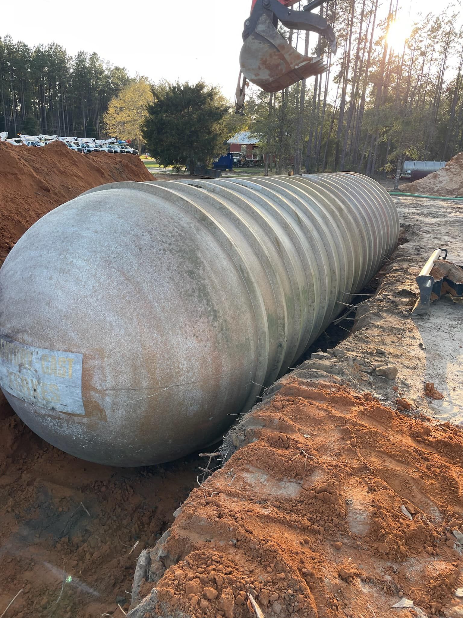 Heavy Duty Pumping | A large concrete cylinder is sitting in the dirt.