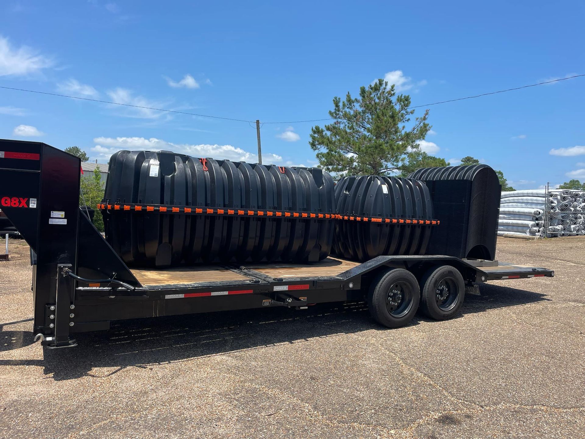 Heavy Duty Pumping | A trailer with a large tank on it is parked in a gravel lot.