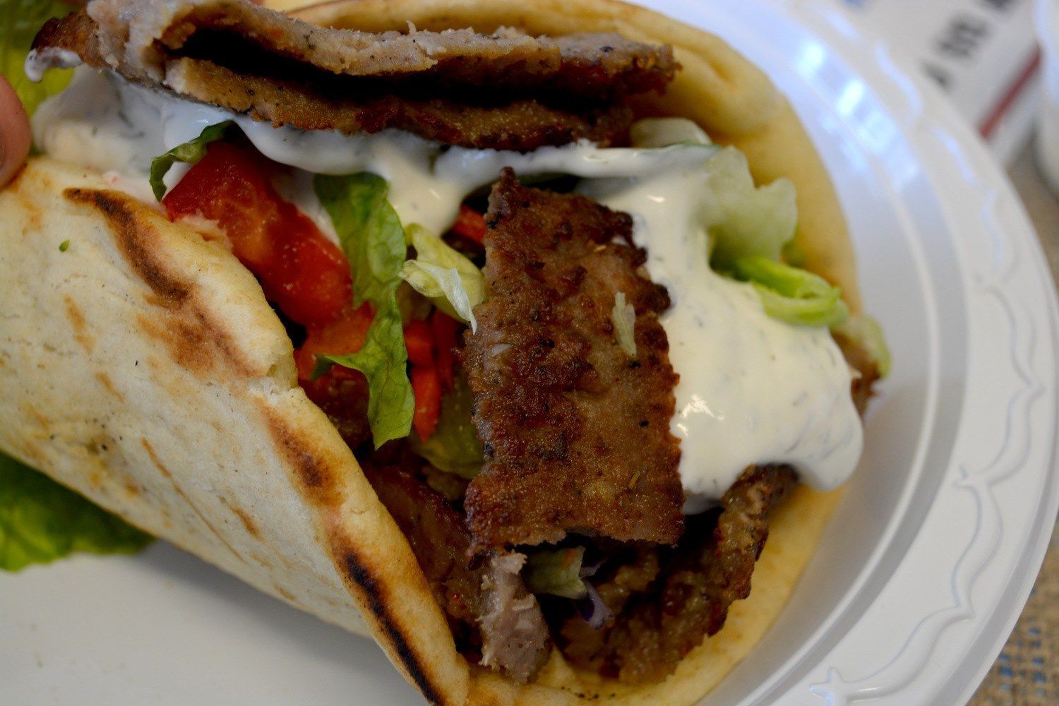 A close up of a gyro sandwich on a plate.