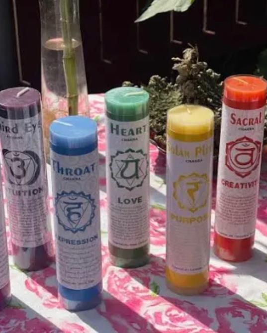 A bunch of candles on a table with one that says heart