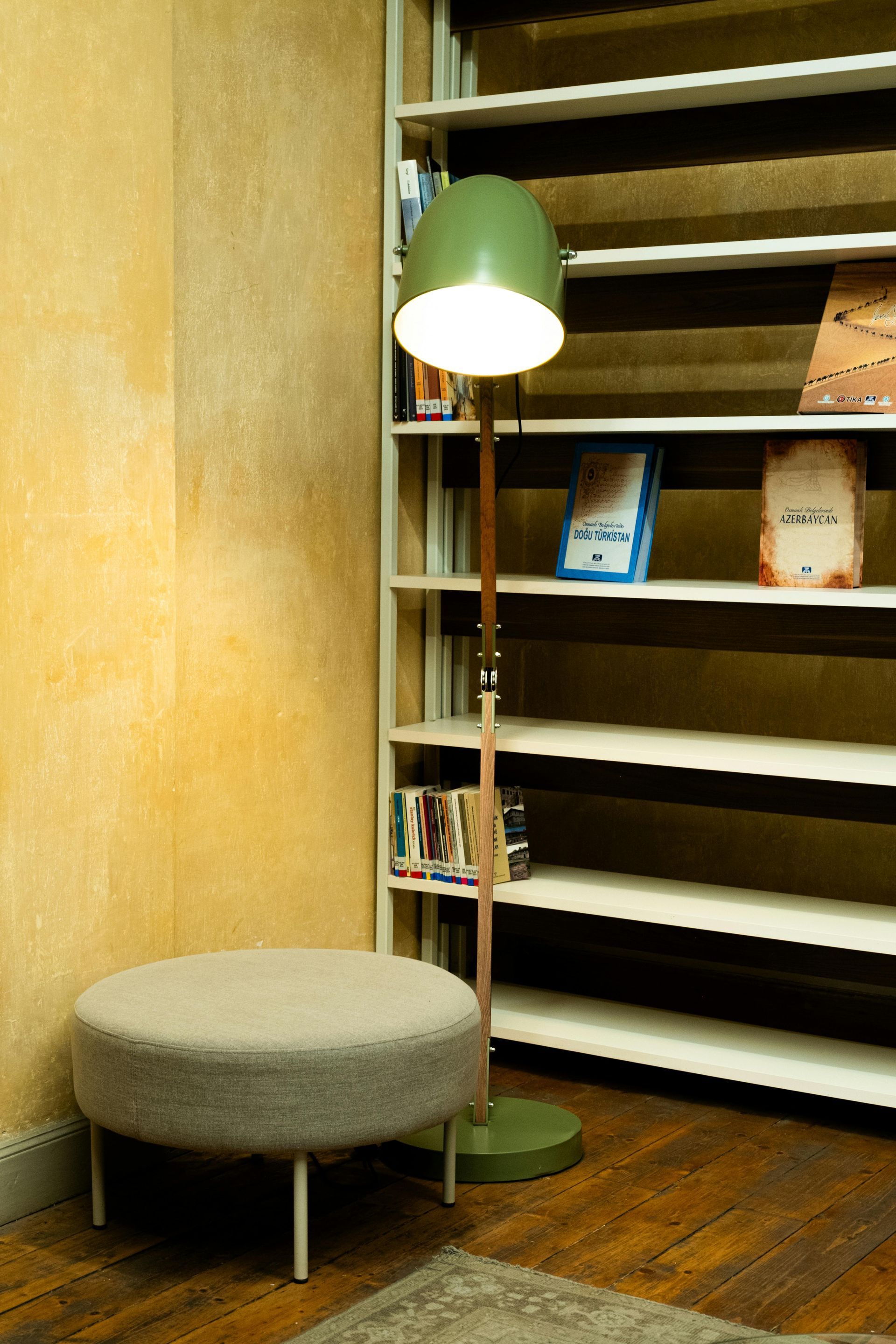 A lamp is sitting in front of a bookshelf with books on it