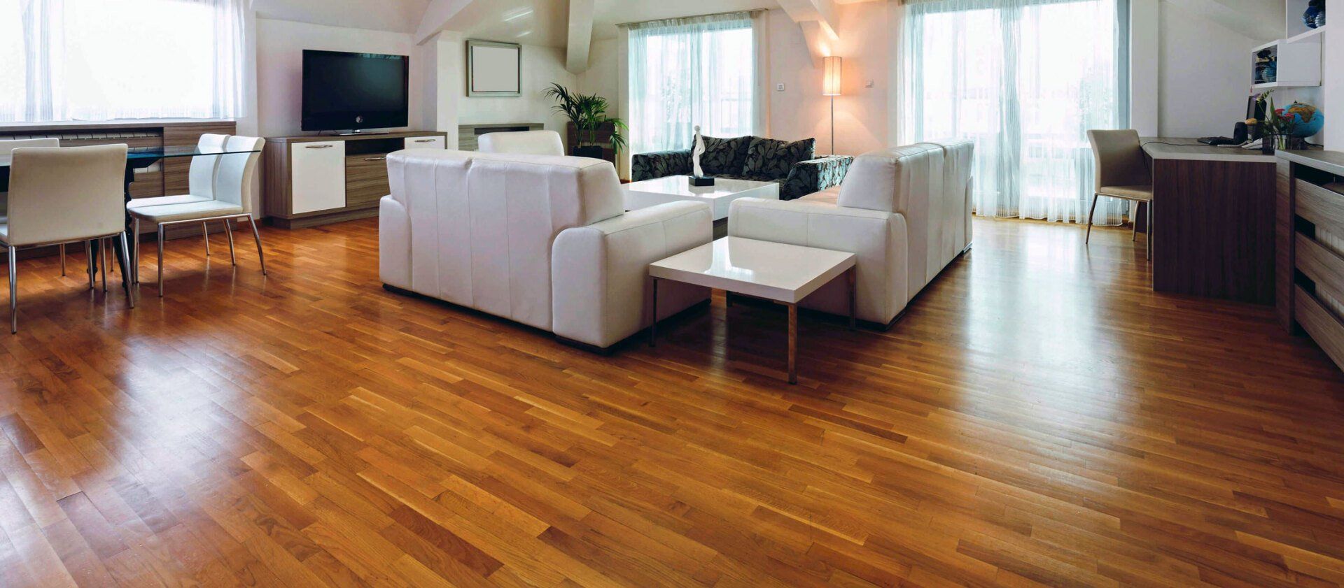 A living room with hardwood floors and white furniture