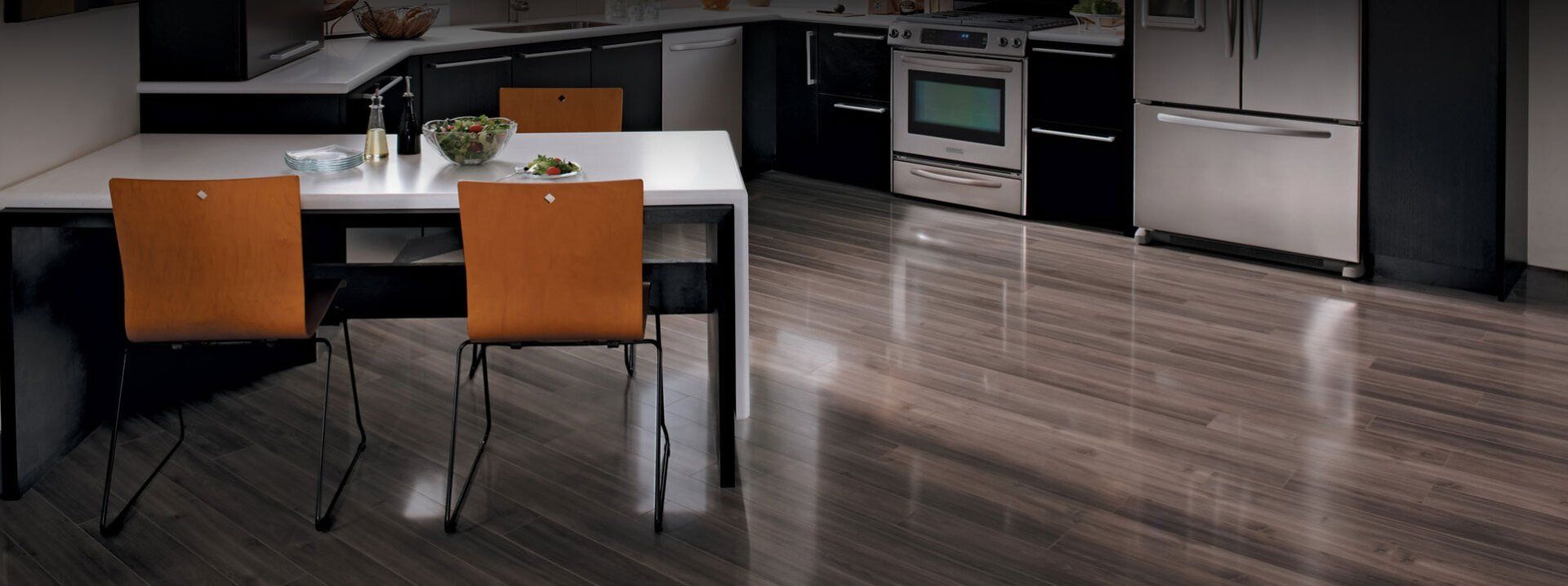 A kitchen with a table and chairs and a wooden floor.