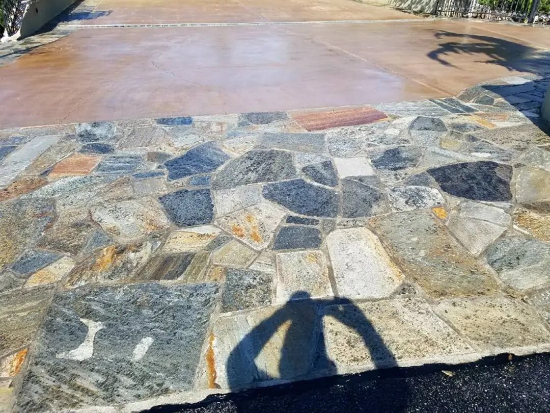 A shadow of a person is cast on a stone walkway.