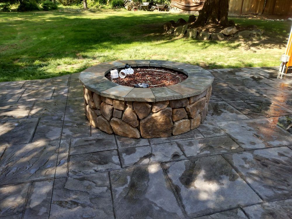 A fire pit is sitting on top of a concrete patio.