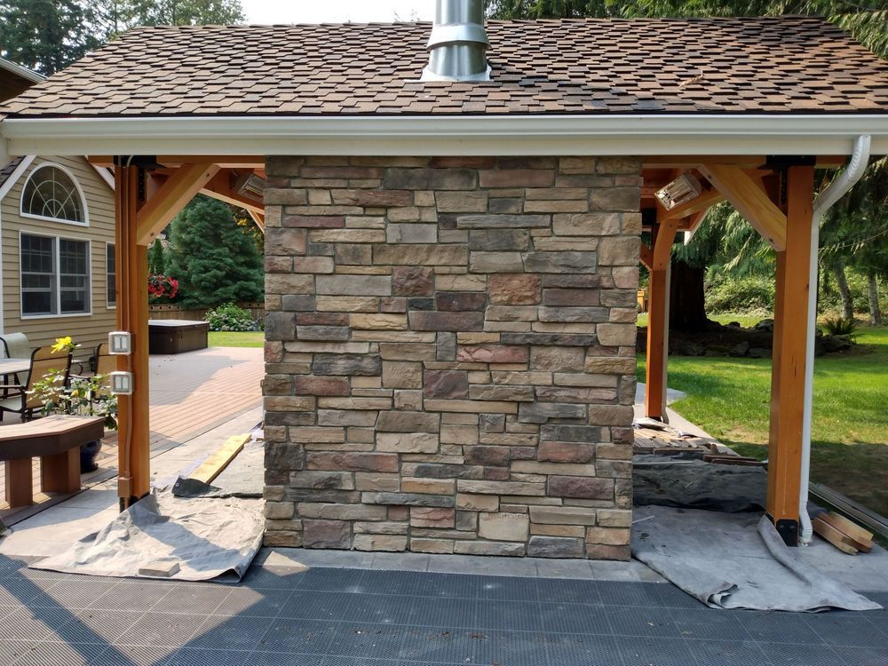 A house with a stone wall and a wooden roof