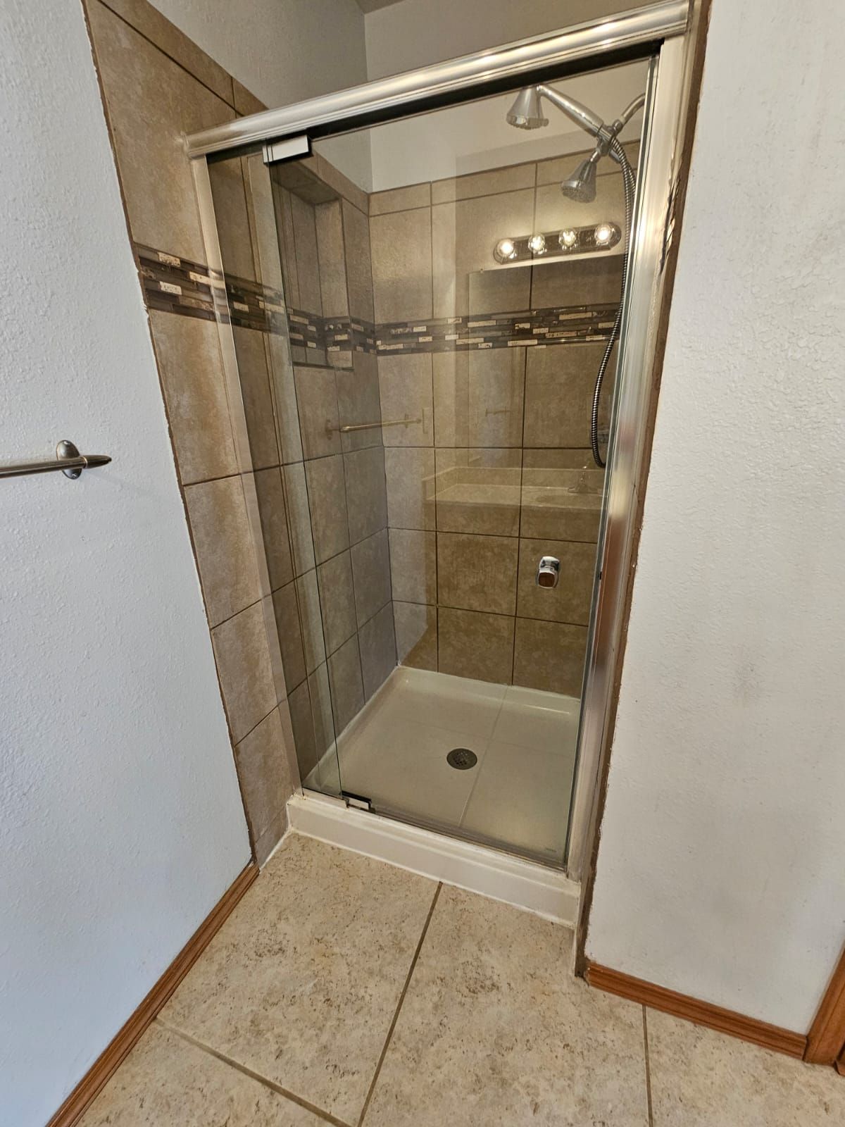 A bathroom with a walk in shower and a sink.