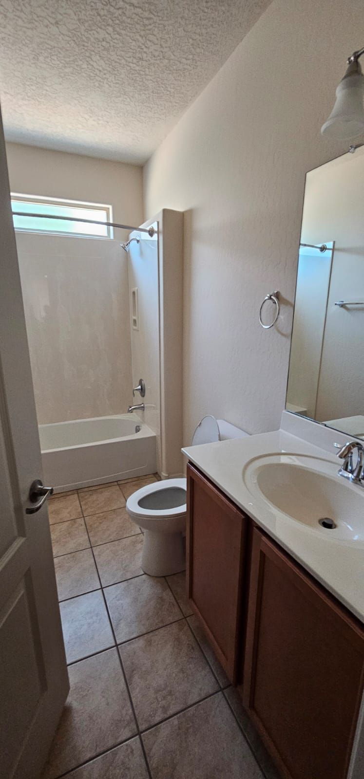 A bathroom with a toilet , sink , tub and mirror.
