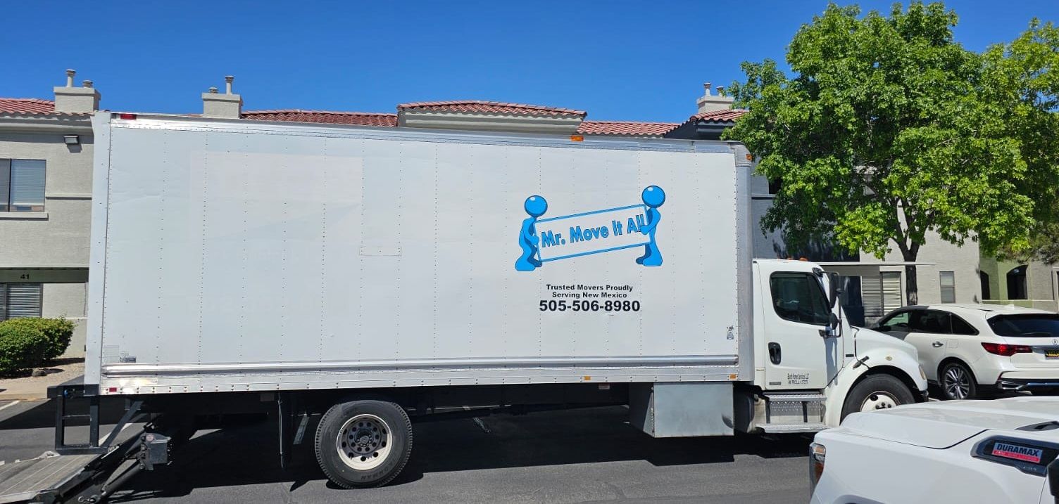 A white moving truck is parked on the side of the road.