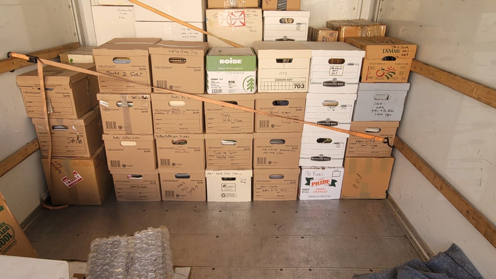 A truck filled with lots of cardboard boxes stacked on top of each other.