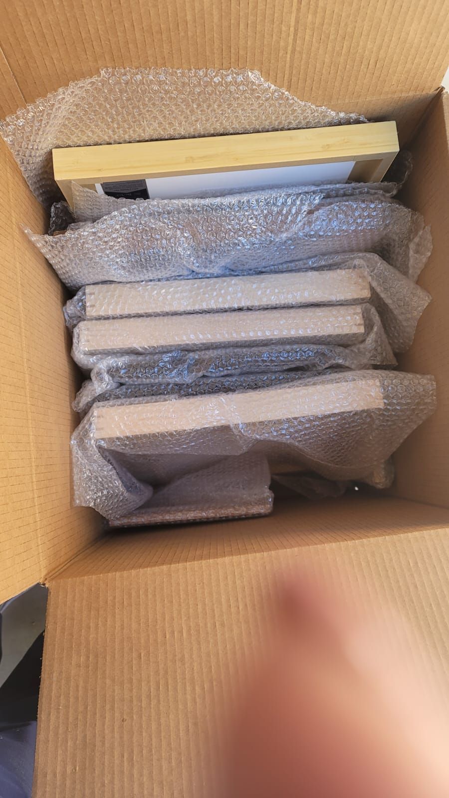 A cardboard box filled with bubble wrap and books.