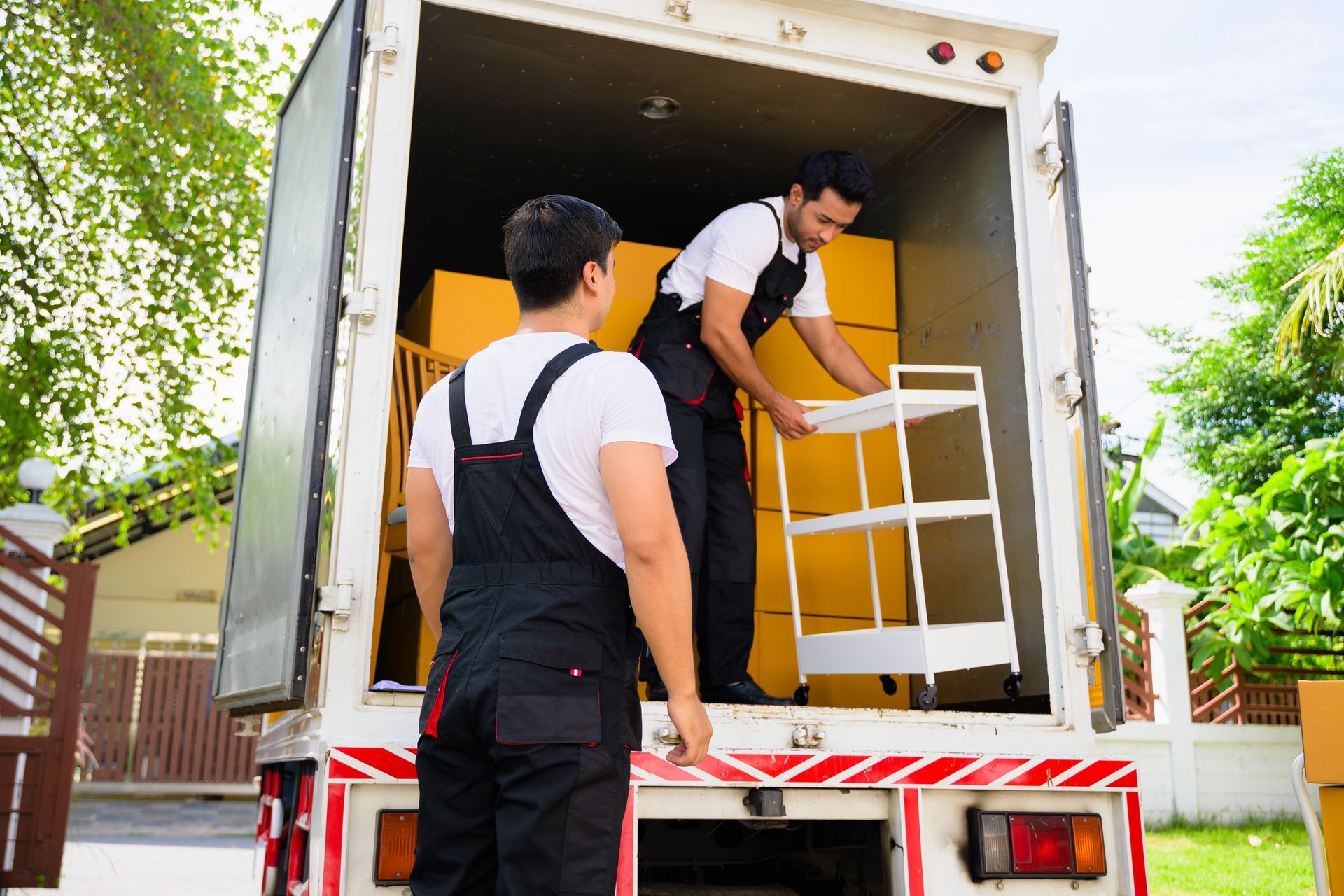 Two men are loading furniture into a moving truck.