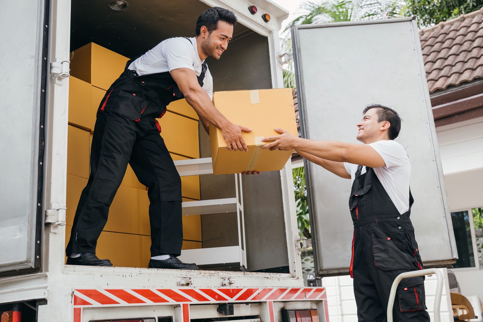 Two men are loading boxes into a truck.