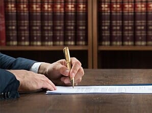 Lawyer Writing On Legal Documents At Desk — Notary Testimonials in Oxnard, CA