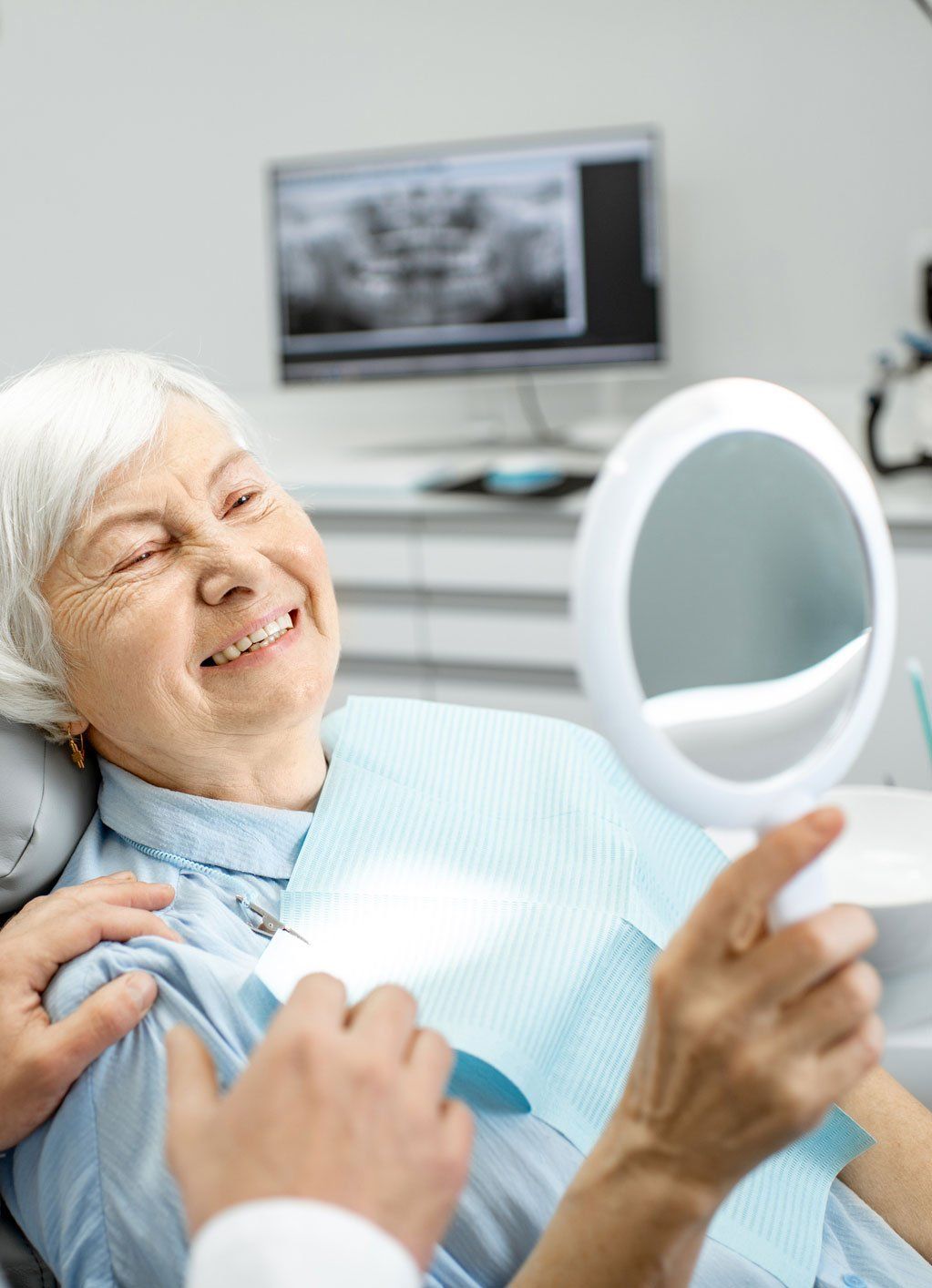 mature patient looking in mirror and smiling