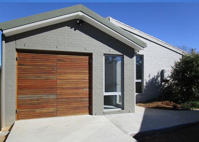 A gray house with a wooden garage door