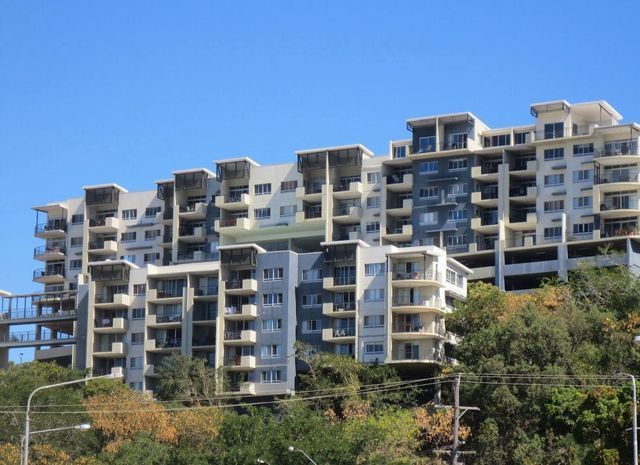 A large apartment building sitting on top of a hill