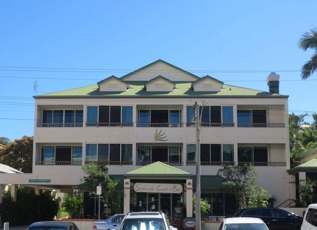 A large white building with a green roof
