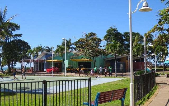 A park with a fence and a bench in the foreground