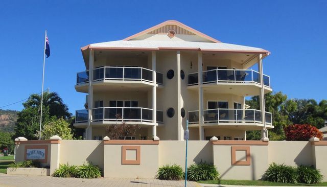 A large building with balconies and a flag in front of it