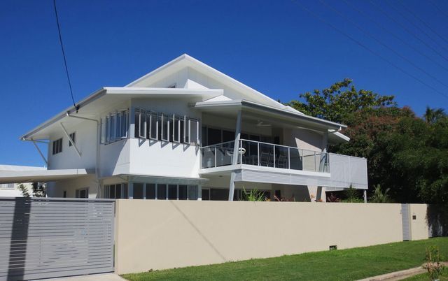 A large white house with a balcony and a fence