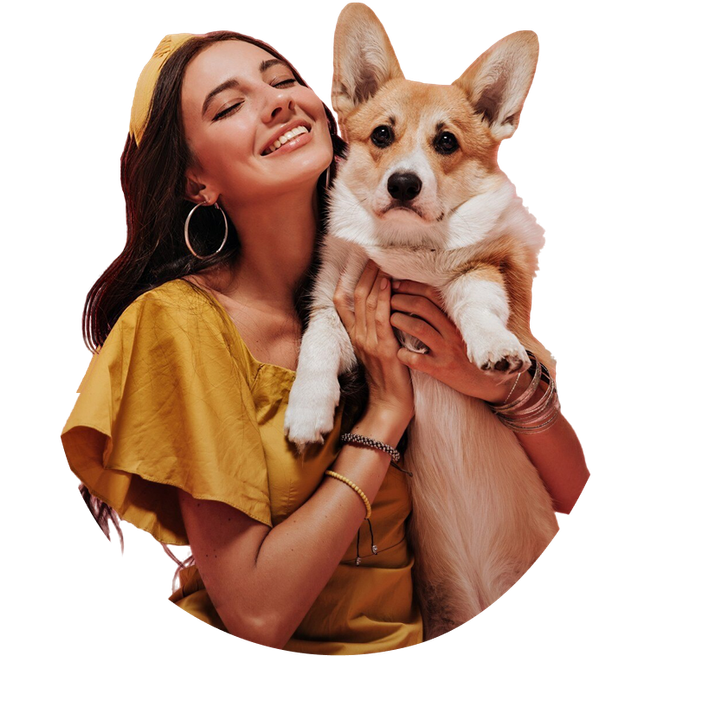 A woman in a yellow dress is holding a corgi dog