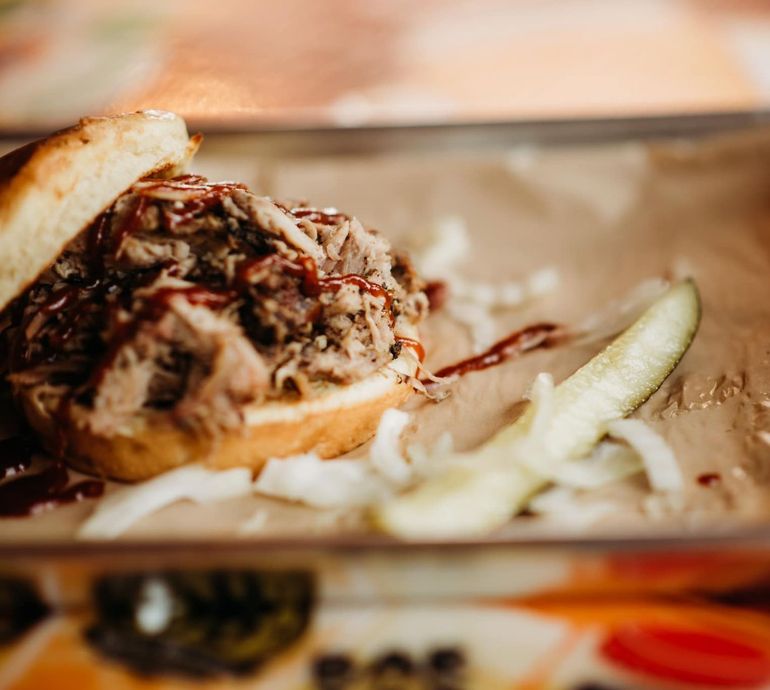 A close up of a sandwich with meat and onions on a table