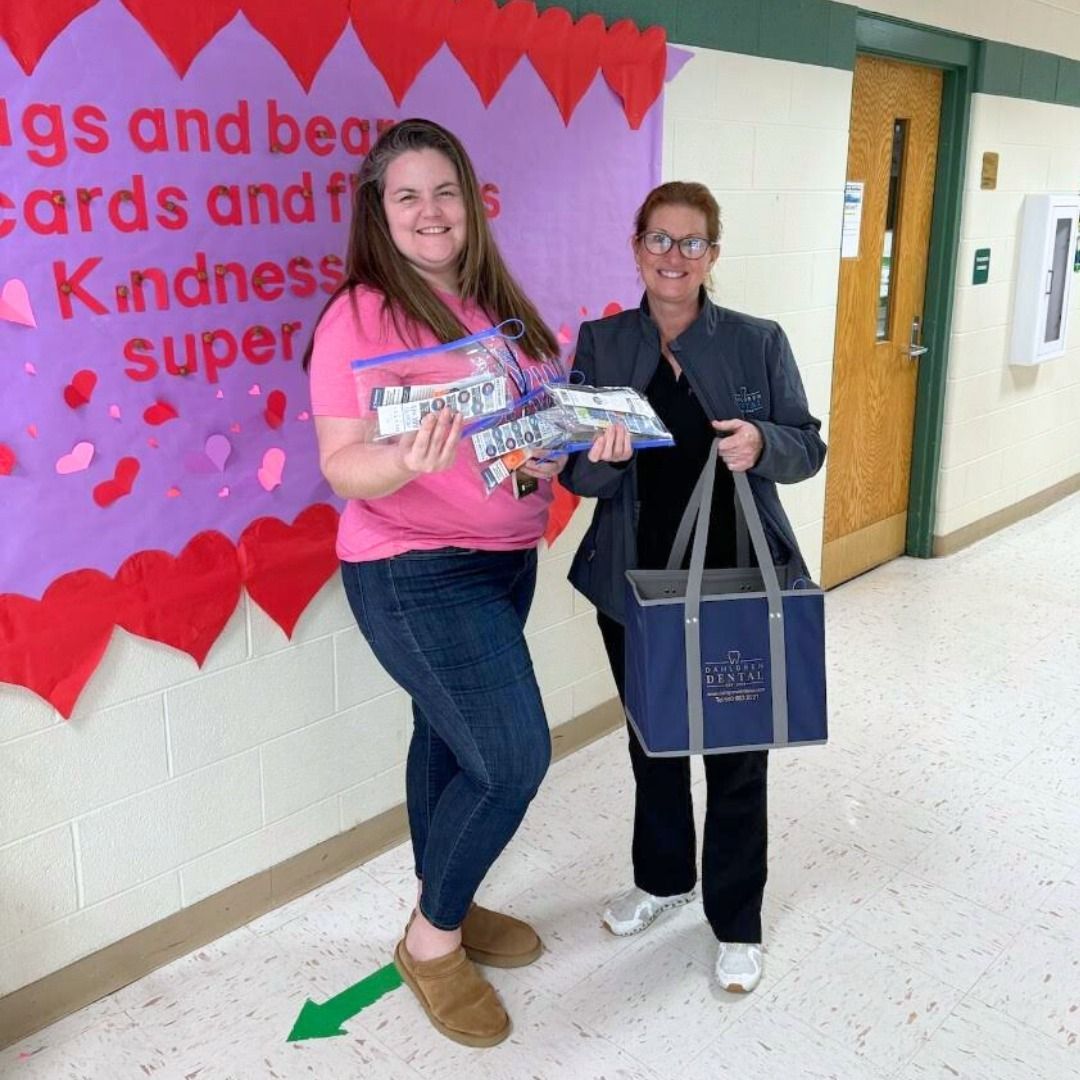 Two women standing in front of a sign that says kindness super