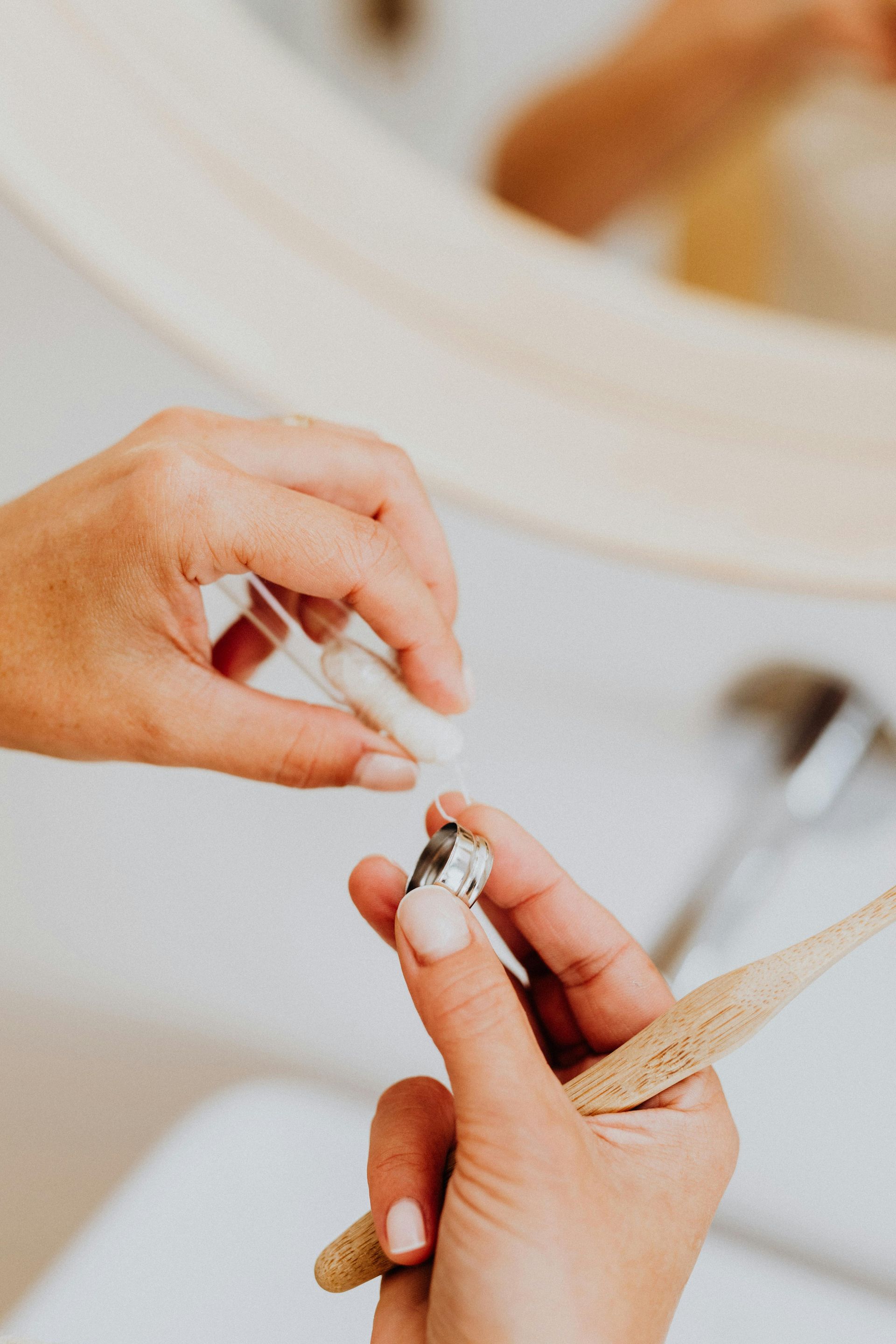 A woman is brushing her teeth with a wooden toothbrush.