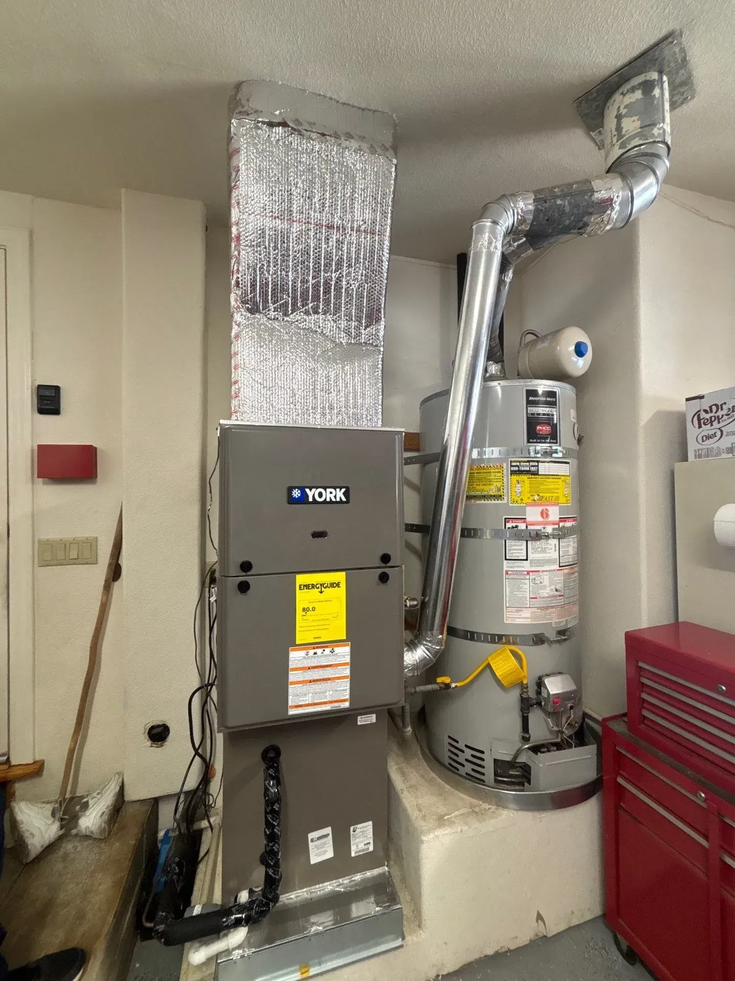 A room with a heater and a water heater in it.
