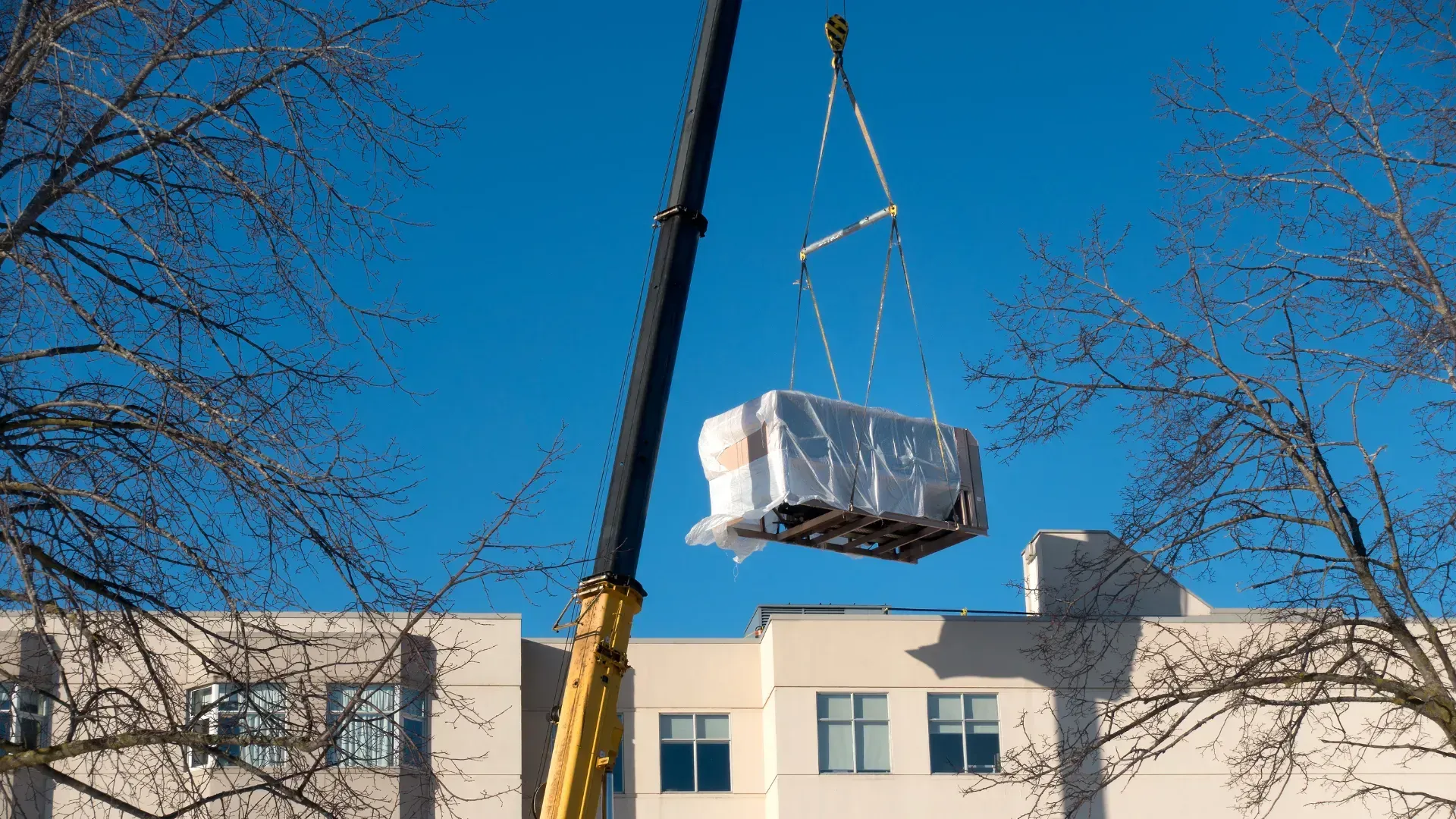 A large piece of equipment is being lifted by a crane.