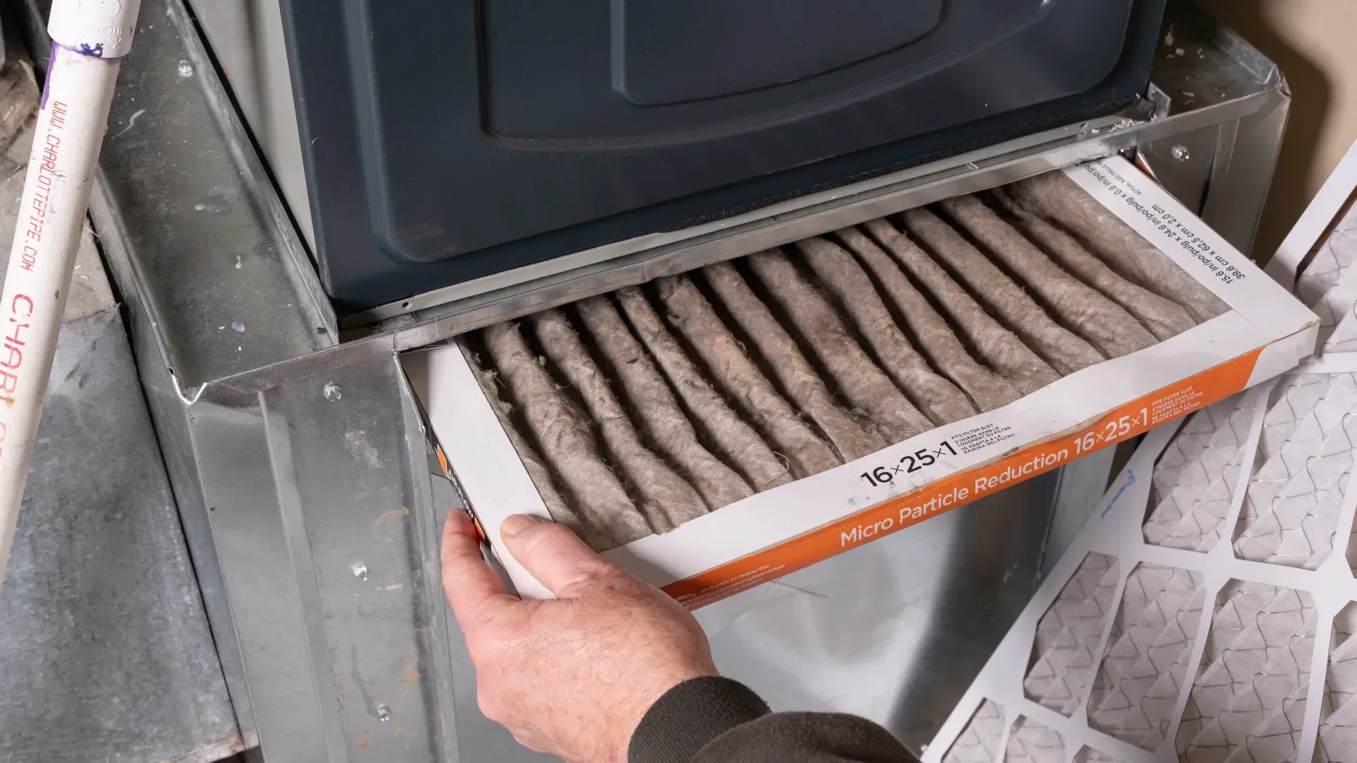 A person is changing a filter on a furnace.